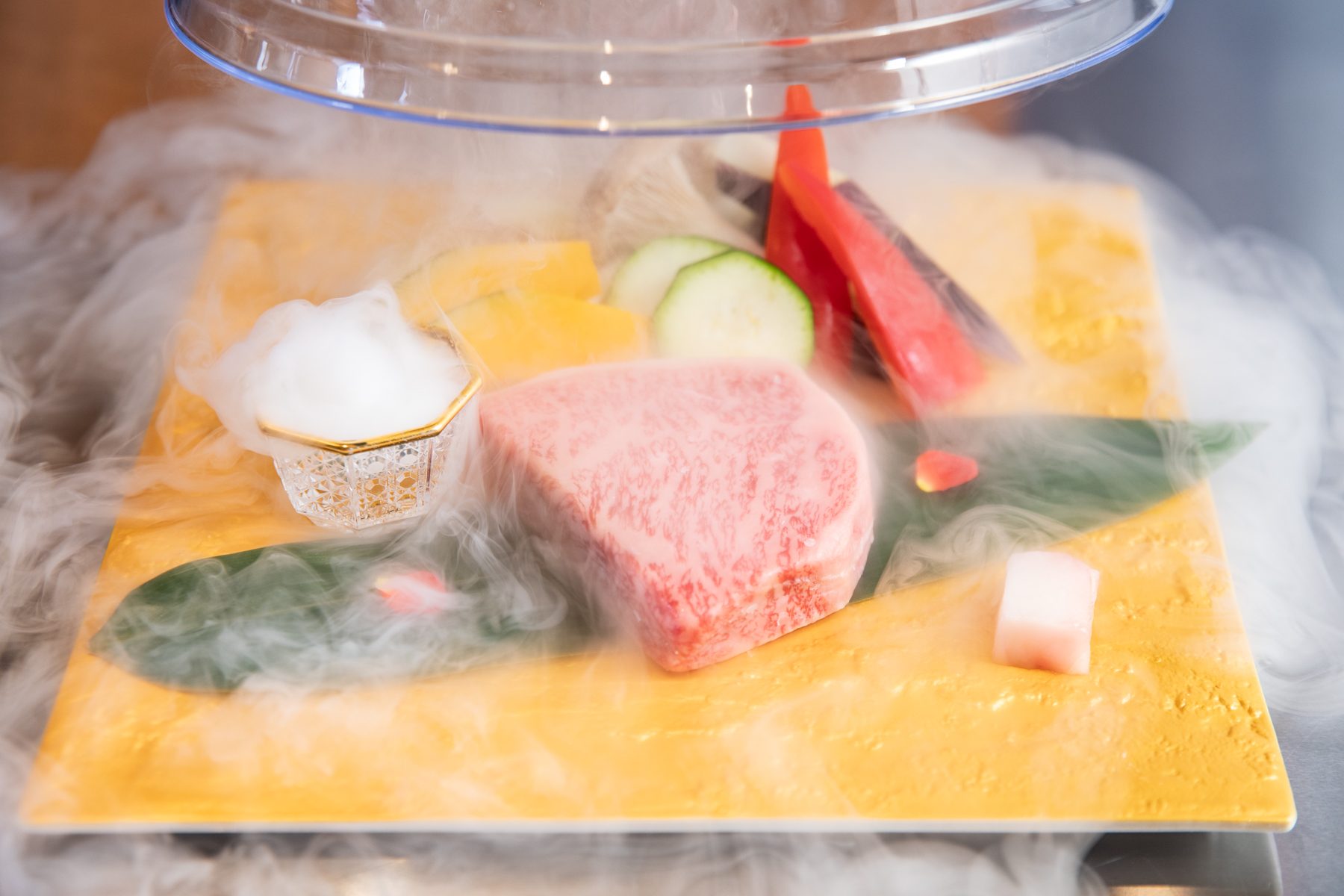 Kobe beef and vegetables before grilling, presented in dry-ice mist